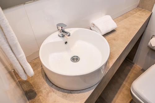 a white sink sitting on a counter in a bathroom at Departamentos nuevos, excelente ubicación en el centro de Salta in Salta