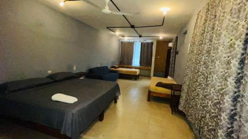 a bedroom with a bed and a living room at Casa Laura in Puerto Escondido