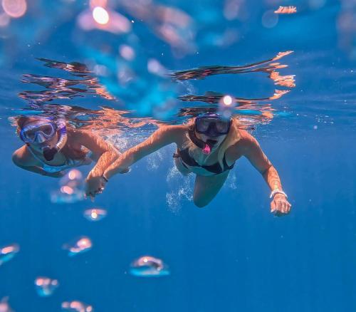 two women swimming in the water in the pool at Mathiveri Thundi Inn in Mathiveri