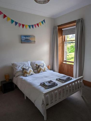 a white bed in a bedroom with a window at Victorian Home in Moray in Forres