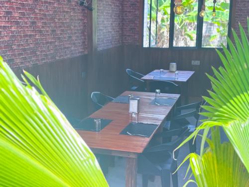 two tables and chairs in a room with plants at Mathiveri Thundi Inn in Mathiveri