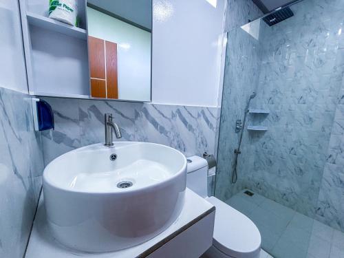 a white bathroom with a sink and a toilet at Mathiveri Thundi Inn in Mathiveri
