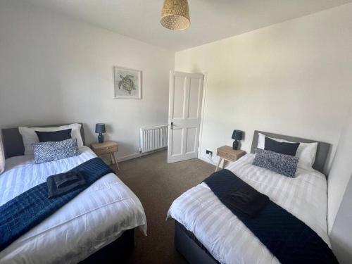 a bedroom with two beds and two night stands at Charming Seaside home Sleeps 4 with free parking in Broughty Ferry