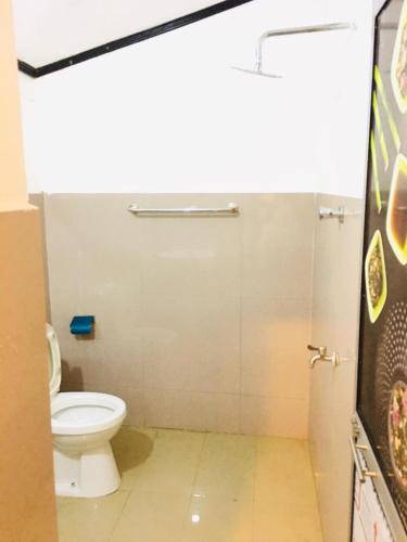 a bathroom with a white toilet in a stall at Bracedale Estate in Kegalle