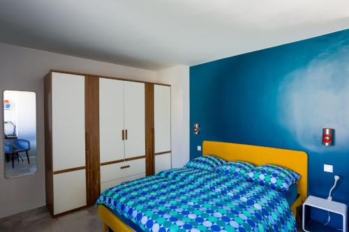 - une chambre bleue avec un lit et un mur bleu dans l'établissement Lyon Premium - Happy 70's, à Villeurbanne