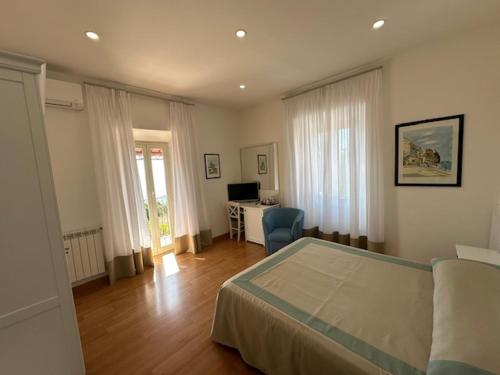 a bedroom with a bed and a desk with a computer at Hotel L'Isola in Santa Marinella