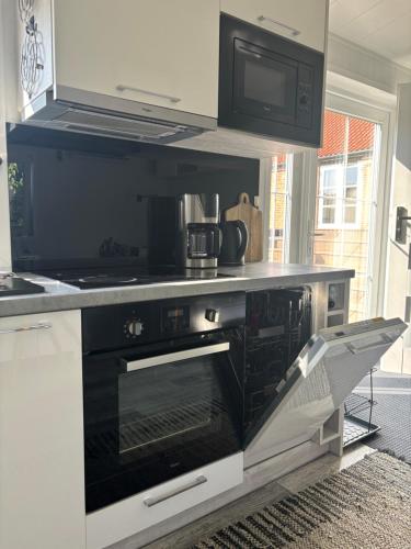 a kitchen with a stove and a microwave at TheLittleHouse-By-The-Lake in Hørsholm