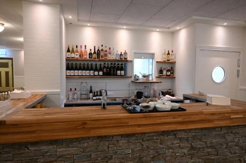 a bar in a room with a counter with alcohol at Rold Gl Kro in Arden