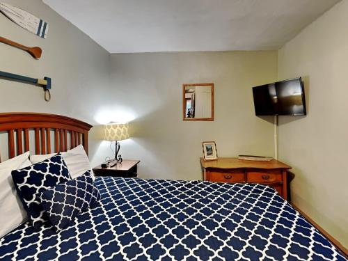 a bedroom with a blue and white bed and a television at Cabin Lodge in Oakland