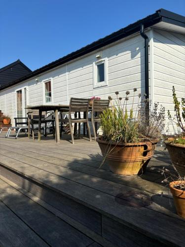 a deck with a table and chairs and potted plants at TheLittleHouse-By-The-Lake in Hørsholm