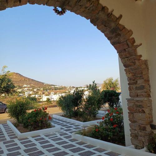 a view from the courtyard of a house with an archway at Lofos Studios in Agios Prokopios