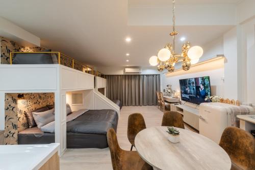 a living room with a bunk bed and a dining room at FM Ratchada in Ban Na Song