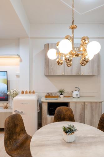 a kitchen with a table with chairs and a chandelier at FM Ratchada in Ban Na Song