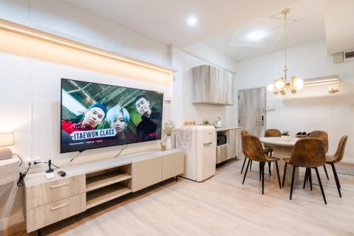 a kitchen and dining room with a flat screen tv at FM Ratchada in Ban Na Song