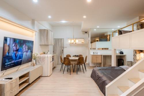 a living room with a bed and a dining room and a kitchen at FM Ratchada in Ban Na Song