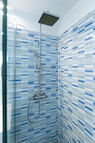 a bathroom with a shower with blue tiles at Bellavista in Tías
