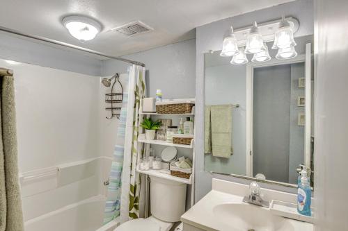 a bathroom with a sink and a toilet and a mirror at Daytona Beach Condo with Balcony 5 Mi to Speedway! in Daytona Beach