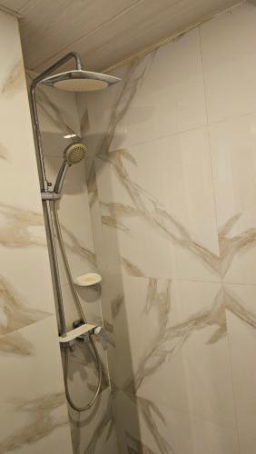 a shower in a bathroom with marble walls at Lydia's House in Kaputian