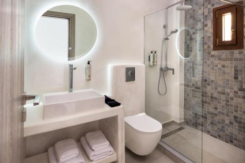 e bagno con lavandino, servizi igienici e doccia. di Santorinn Suites Fira a Firà
