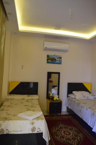 a room with two beds and a mirror at Karma Kono in Abu Simbel