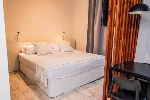 a bedroom with a bed with white sheets and pillows at Departamentos nuevos, excelente ubicación en el centro de Salta in Salta