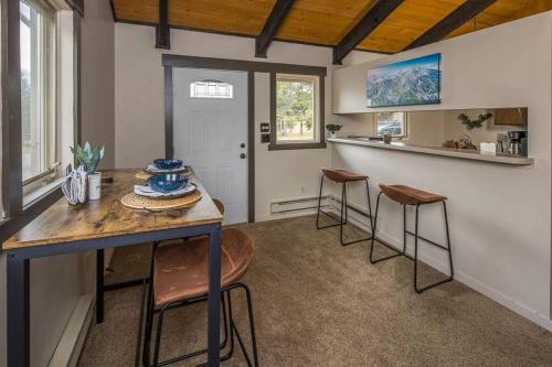 Una cocina con una mesa y taburetes en una habitación. en Condo Adjacent Nordic Ski, Fireplace & Indoor Pool, en Big Sky Meadow Village