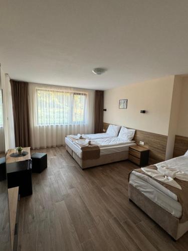 a large bedroom with two beds and a window at Къща Александра 2 in Dobrinishte