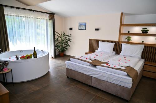 a bedroom with a bed and a bath tub at Къща Александра 2 in Dobrinishte