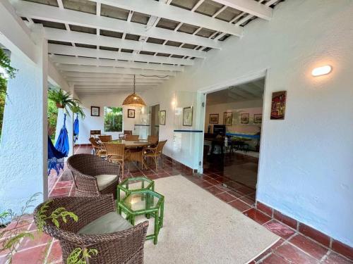 a patio with a table and chairs and a dining room at Casa Calú in Guarujá