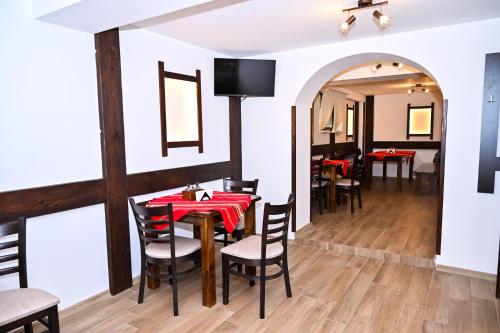 a dining room with a red table and chairs at Къща Александра 2 in Dobrinishte