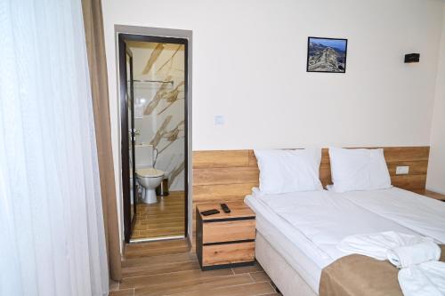 a bedroom with a bed and a bathroom with a mirror at Къща Александра 2 in Dobrinishte