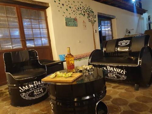 a bar with two chairs and a table with a bottle of booze at Beautiful Country House in Loja