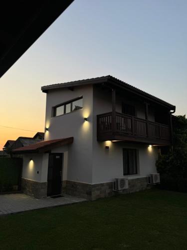 a white house with a balcony on top of it at Къща Александра 2 in Dobrinishte