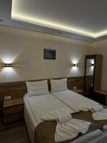 a bedroom with a large bed with towels on it at Къща Александра 2 in Dobrinishte