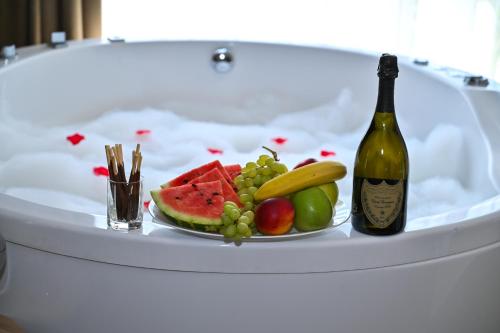 a plate of fruit and a bottle of wine at Къща Александра 2 in Dobrinishte