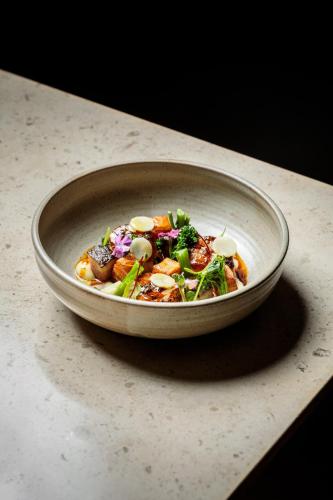 a bowl of food sitting on top of a table at Fairmont Pacific Rim in Vancouver