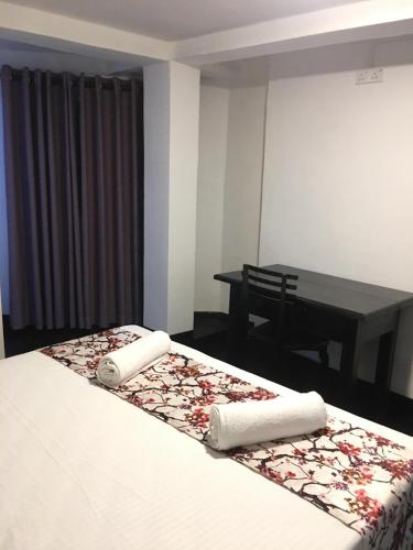 a bedroom with a bed and a table with a table at Bracedale Estate in Kegalle