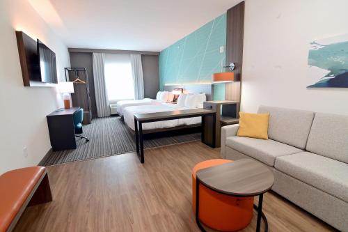 a hotel room with a bed and a couch at Comfort Suites Titusville near Kennedy Space Center in Titusville