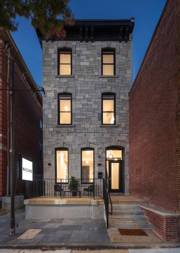a brick building with windows on a street at Kasa The Niche University City Philadelphia in Philadelphia