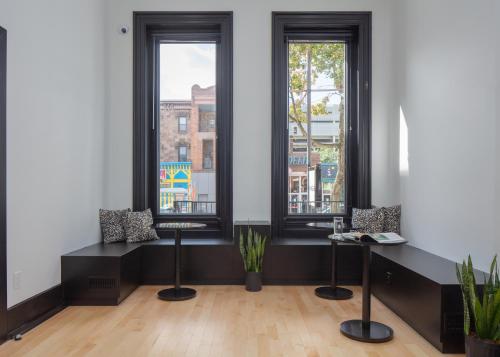 a room with two windows and a table with plants at Kasa The Niche University City Philadelphia in Philadelphia