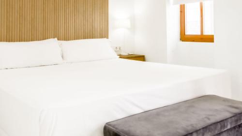 a bedroom with a white bed with a gray mattress at Catalina Suites Apartments Downtown Valencia in Valencia