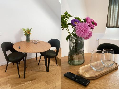 a table with a vase of flowers and a remote control at The Cosy Attic at Casuta Fulgu' in Borşa