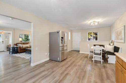 a kitchen and living room with a stainless steel refrigerator at Downtown Windsor Home with Hot Tub and Pool Table in Windsor