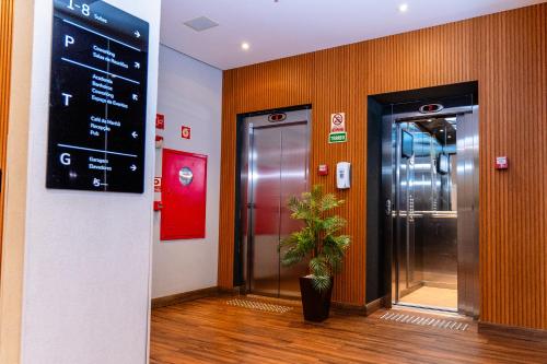 a lobby with an elevator and a sign on the wall at i5 Hotel Águas Claras in Brasilia