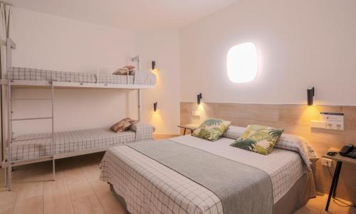 a bedroom with a bed and two bunk beds at Hostal Castilla II Puerta del Sol in Madrid