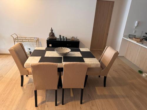 a dining room table with chairs and a bowl on it at Hermoso departamento en el corazón de Condesa in Mexico City