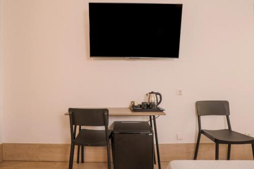 a table with two chairs and a television on a wall at Hostal Castilla II Puerta del Sol in Madrid