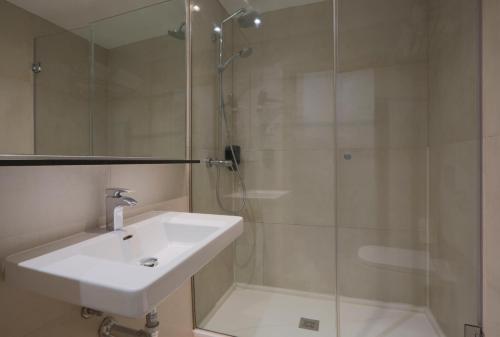 a bathroom with a sink and a glass shower at Hostal Castilla II Puerta del Sol in Madrid