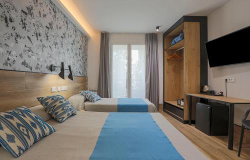a hotel room with two beds and a tv at Hostal Castilla II Puerta del Sol in Madrid