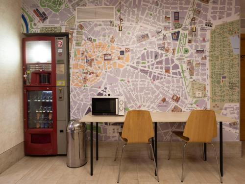 a table with two chairs in front of a map at Hostal Castilla II Puerta del Sol in Madrid